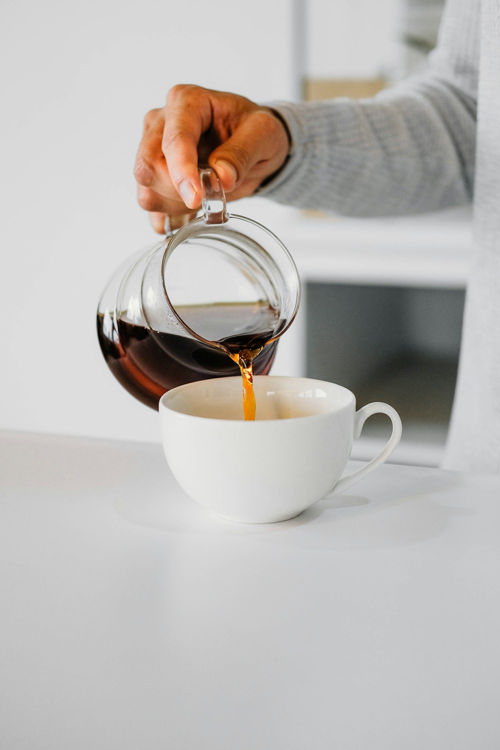 a person pouring coffee into a cup