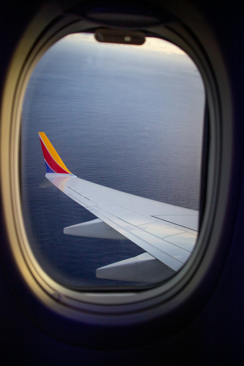 a view of the wing of an airplane over the ocean