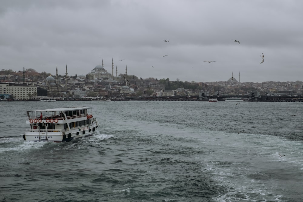 a boat traveling on the water in front of a city