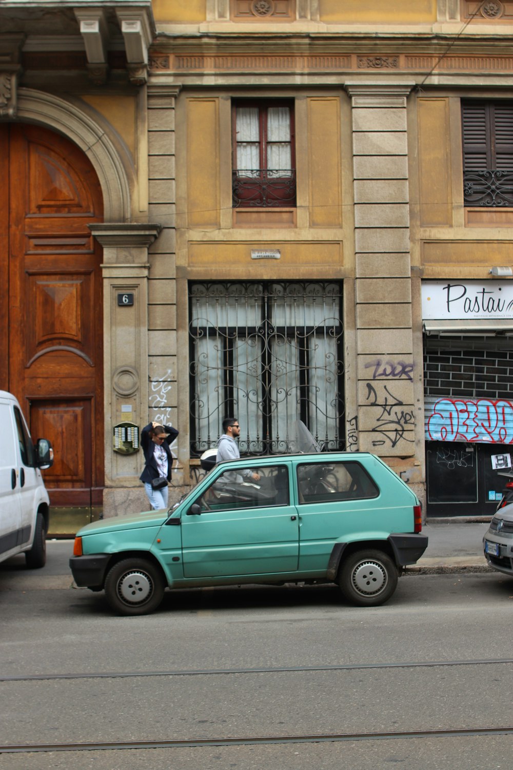 a blue car parked on the side of a street