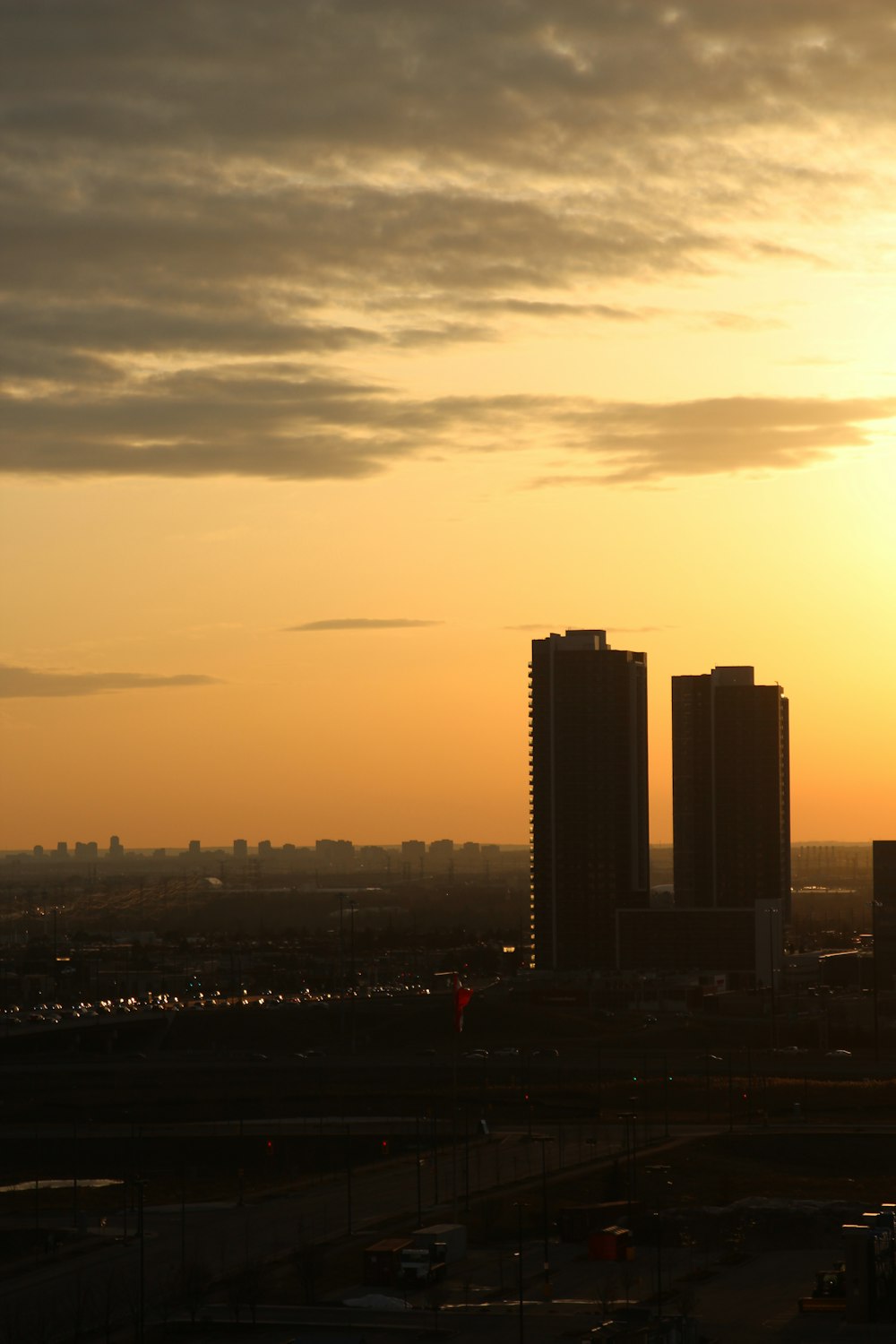 the sun is setting over a city with tall buildings