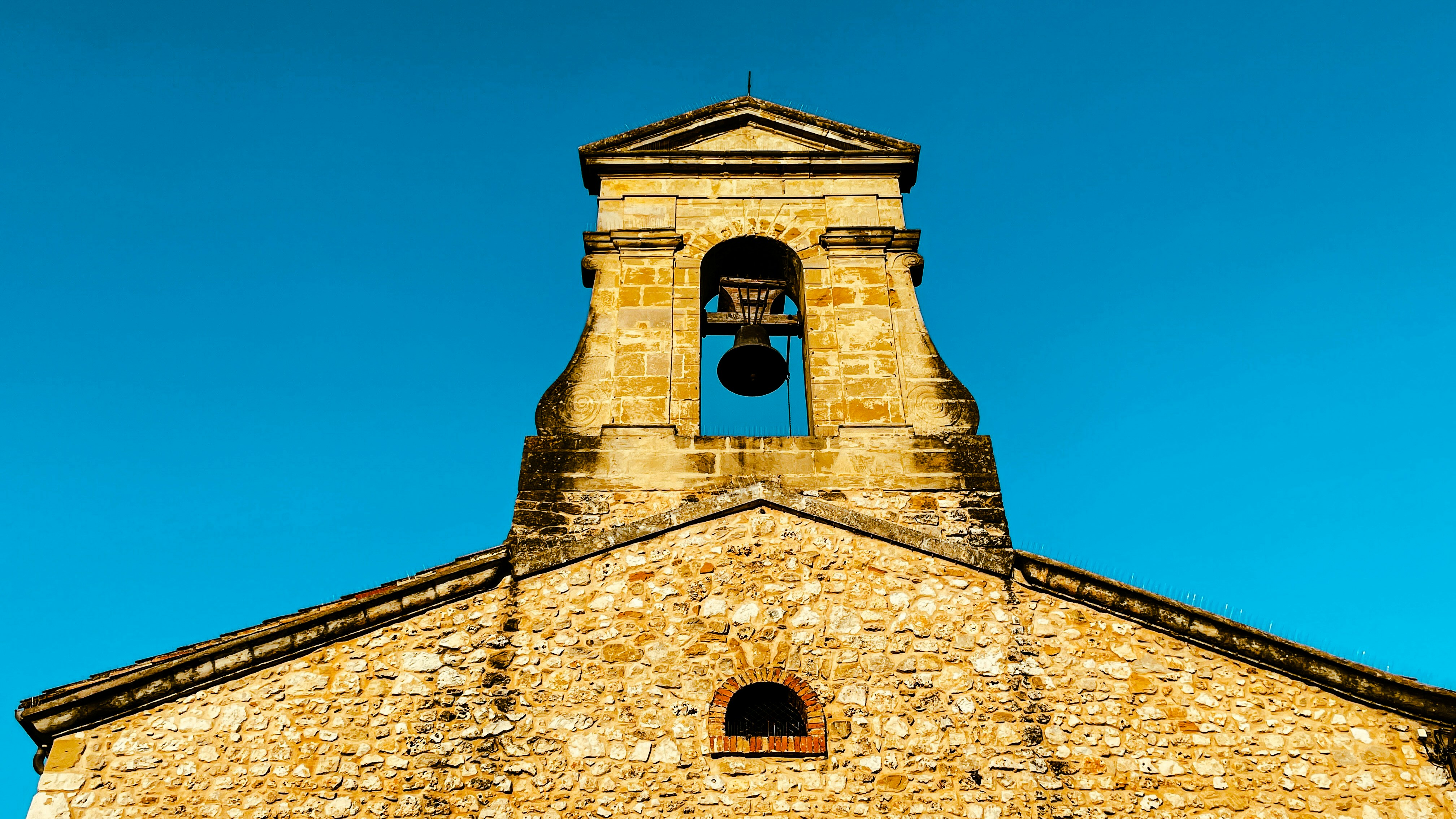 uma torre do sino da igreja com um céu azul no fundo
