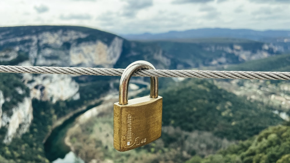 a padlock attached to a rope with mountains in the background