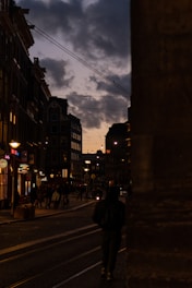 A film crew capturing an emotional scene on a vibrant city street at dusk.