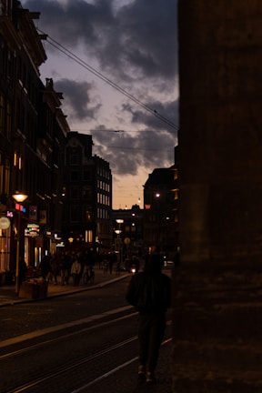 A close-up shot of a vibrant street scene at dusk, capturing lively expressions and warm city lights.