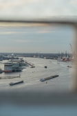 Aerial view of multiple barges lined up along an inland waterway in a small town.
