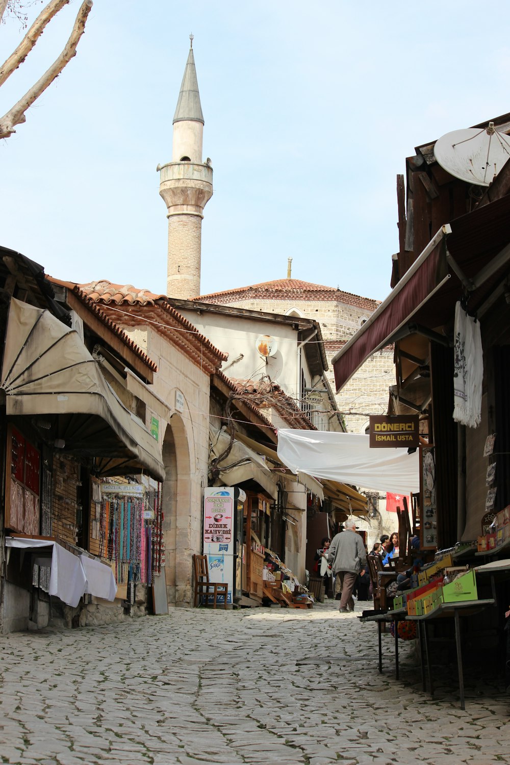 a cobblestone street with a tall white building in the background