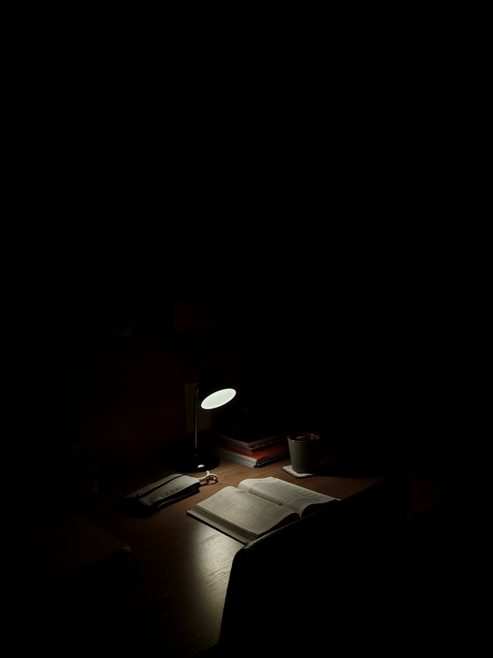 a desk with a lamp and a book on it