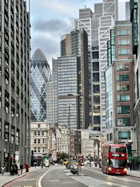 a red double decker bus driving down a city street