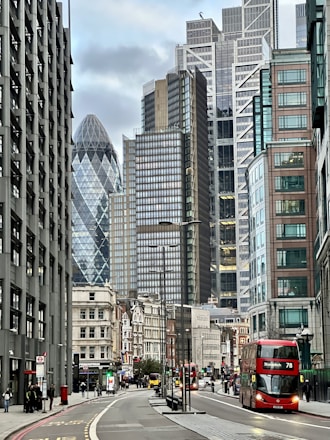 a red double decker bus driving down a city street