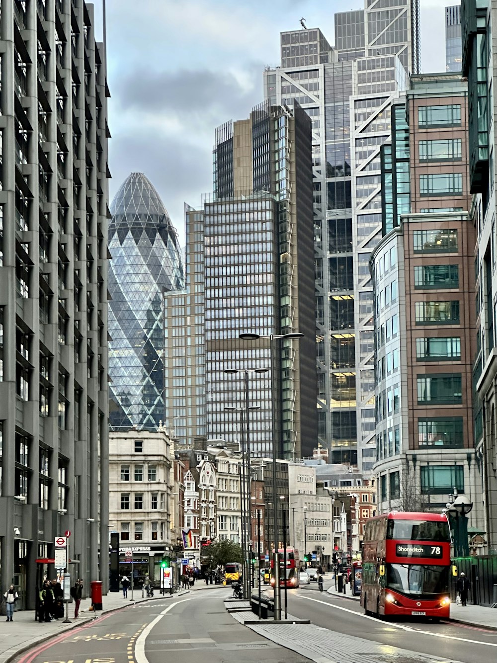 a red double decker bus driving down a city street