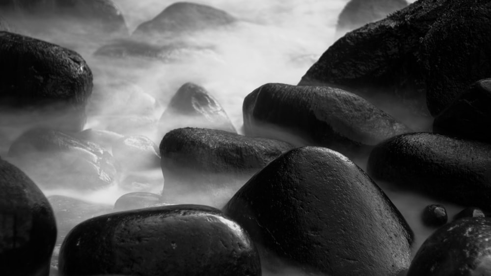 a black and white photo of rocks and water