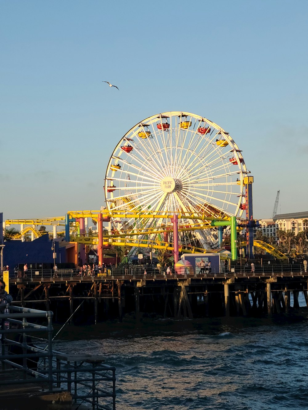 Une grande roue posée au sommet d’une jetée au bord de l’océan