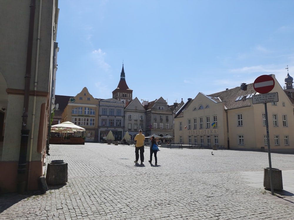 a group of people standing on a cobblestone street