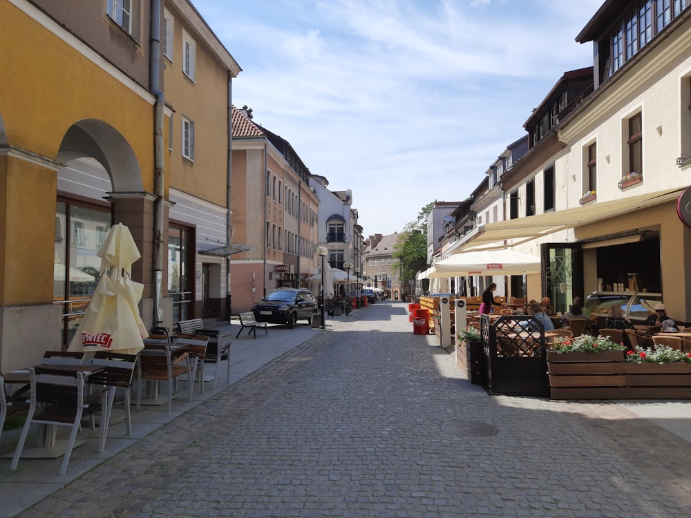 a cobblestone street lined with tables and chairs