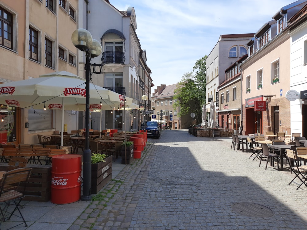 a cobblestone street lined with tables and chairs