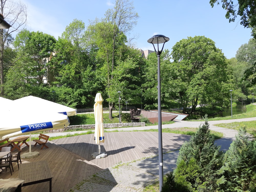 a park with tables and umbrellas on a sunny day