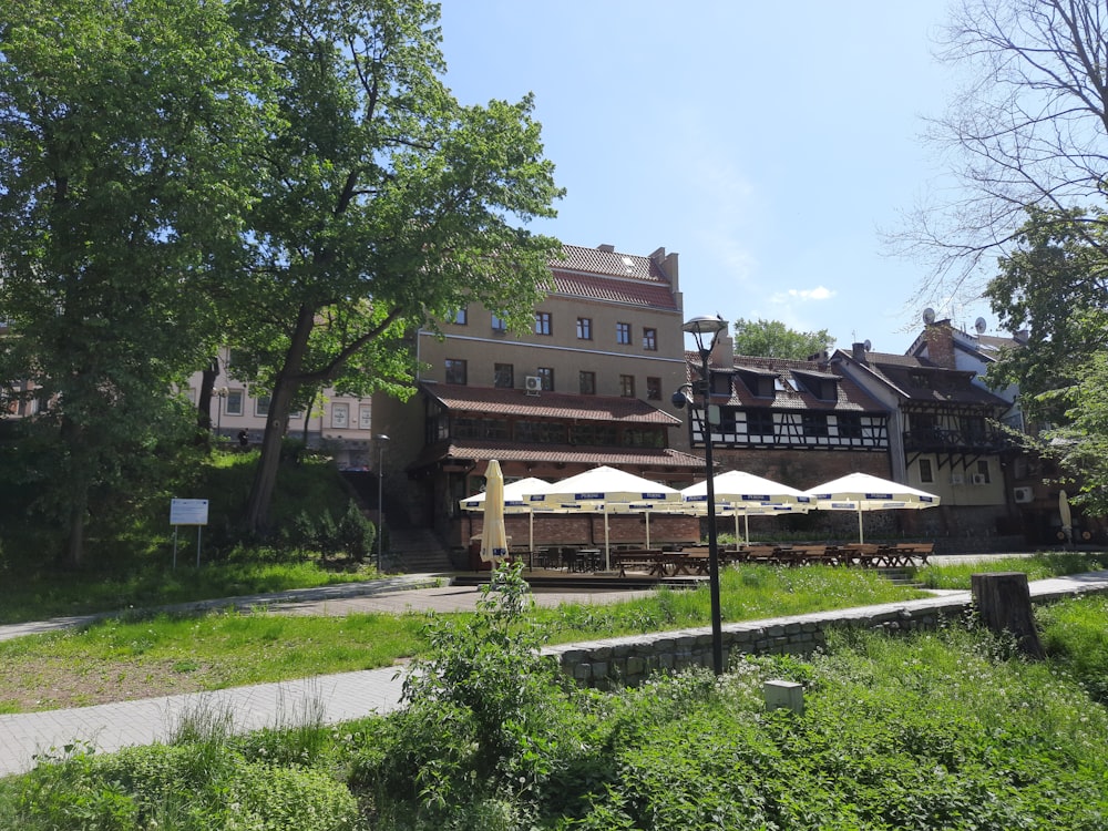 a large building with tables and umbrellas in front of it