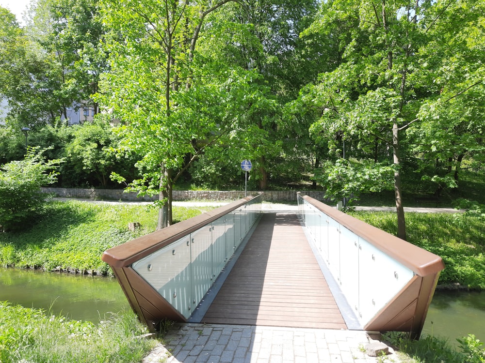 a wooden bridge over a small river in a park