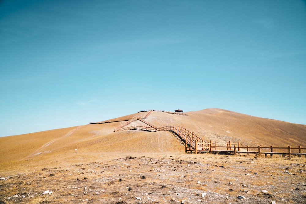 a hill with a wooden fence on top of it