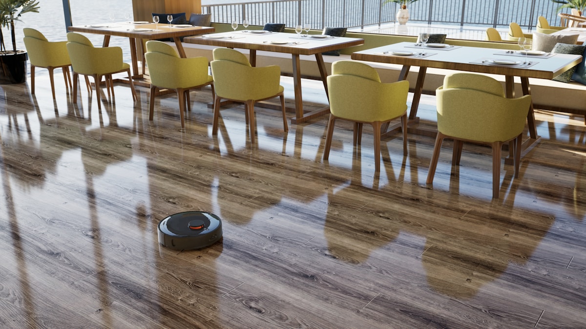 A room with a table, chairs, and a robot on the floor