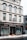 A multi-story building with a white facade and black accents houses a business named Andersons, which offers butcher and takeaway services. Large display windows show some indoor plants and the entrance is centrally located. Snow is piled up on the sidewalk in front of the building.
