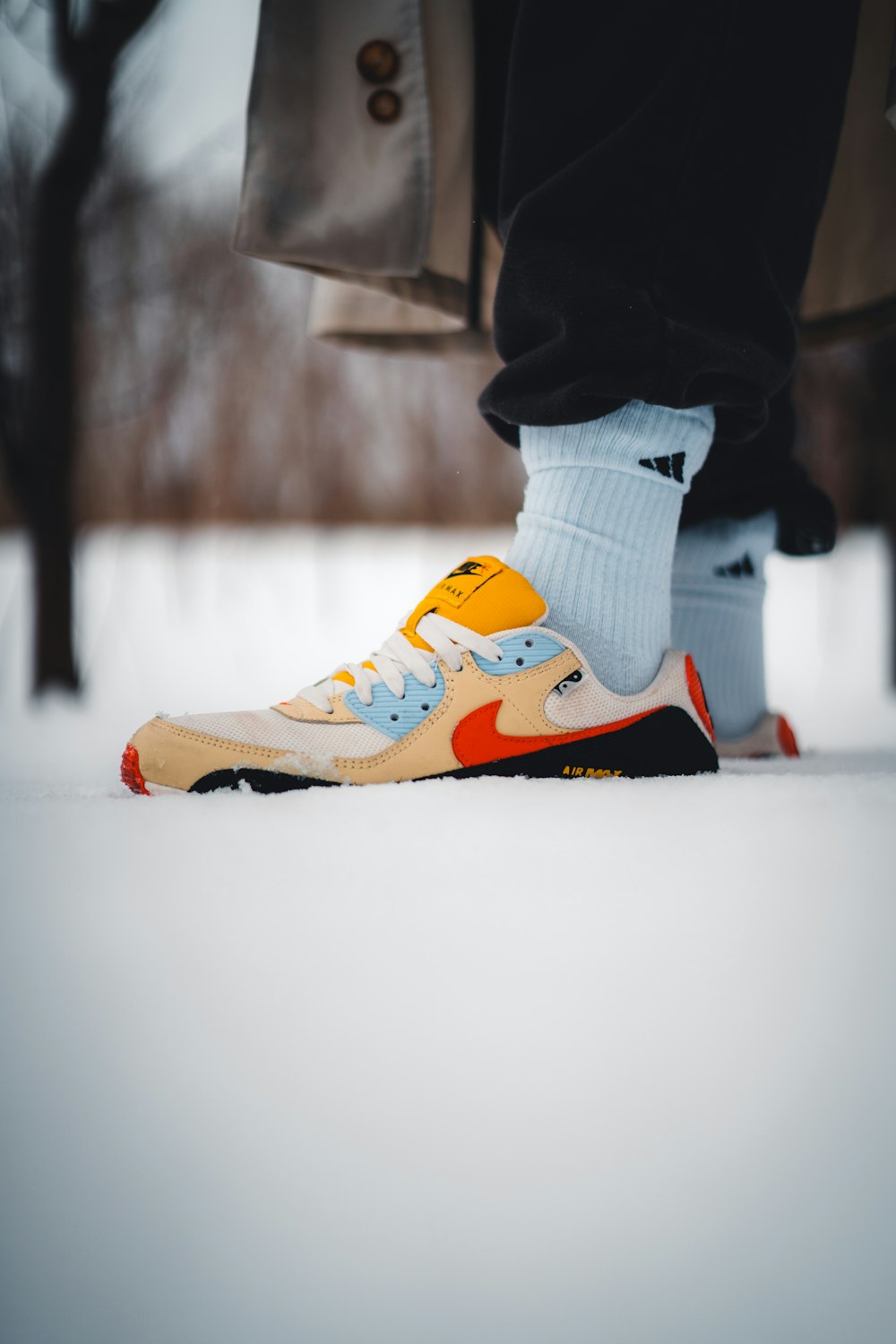 a person standing in the snow wearing a pair of sneakers