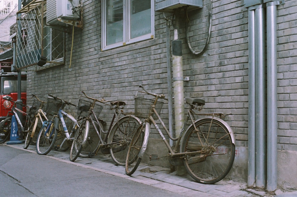 a row of bikes parked next to a brick building