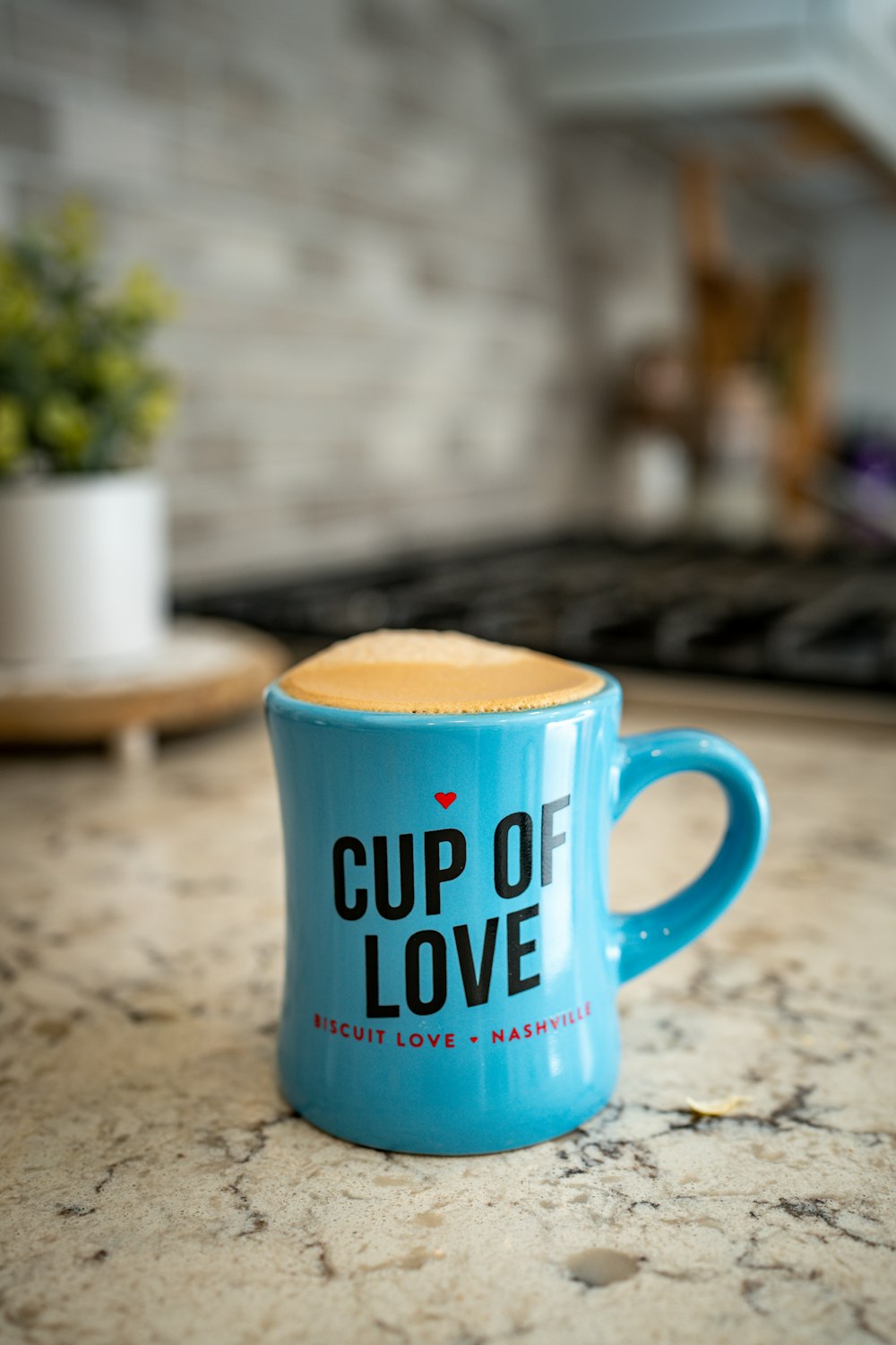 a cup of love mug sitting on a kitchen counter