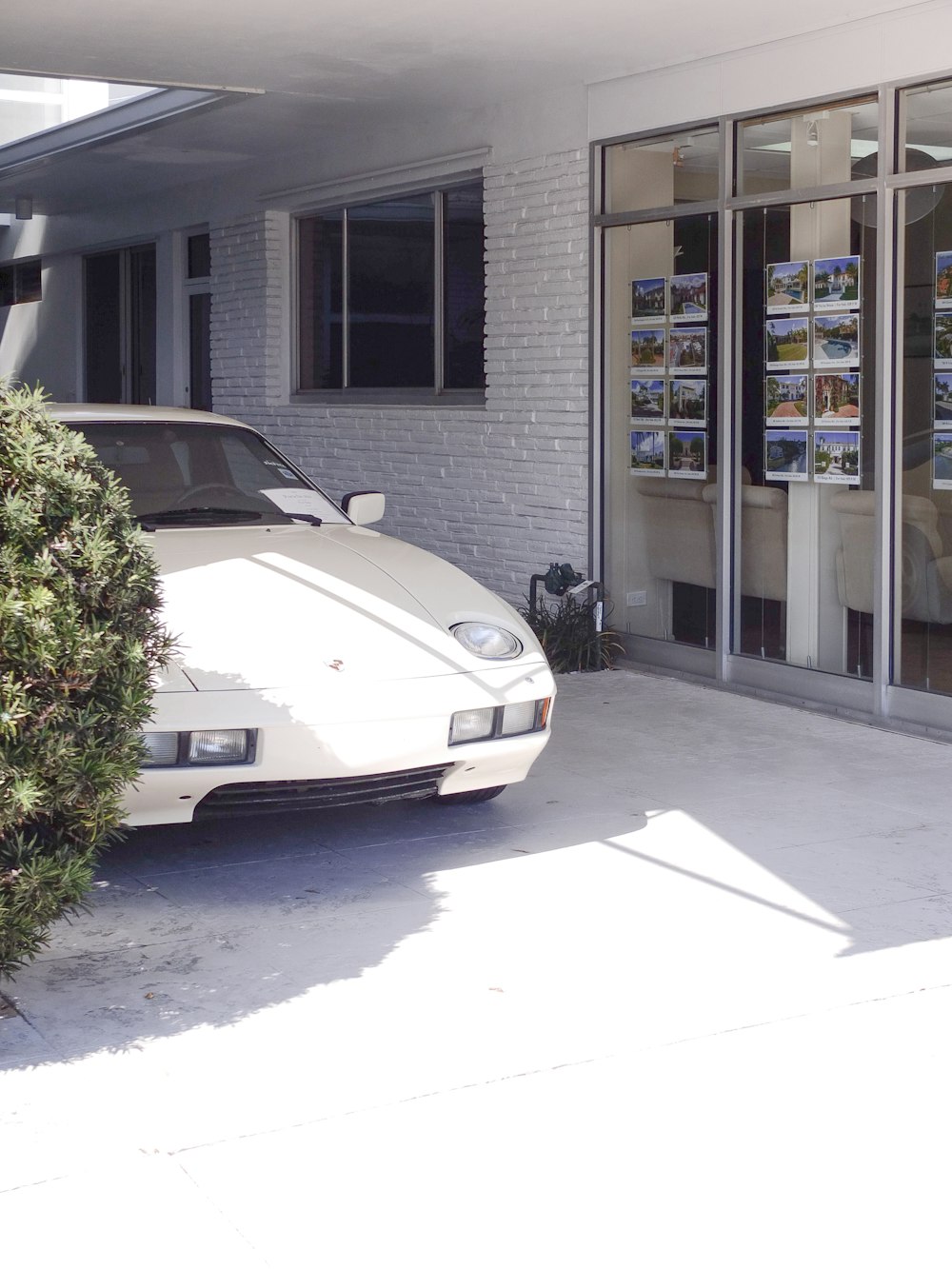 a white sports car parked in front of a building