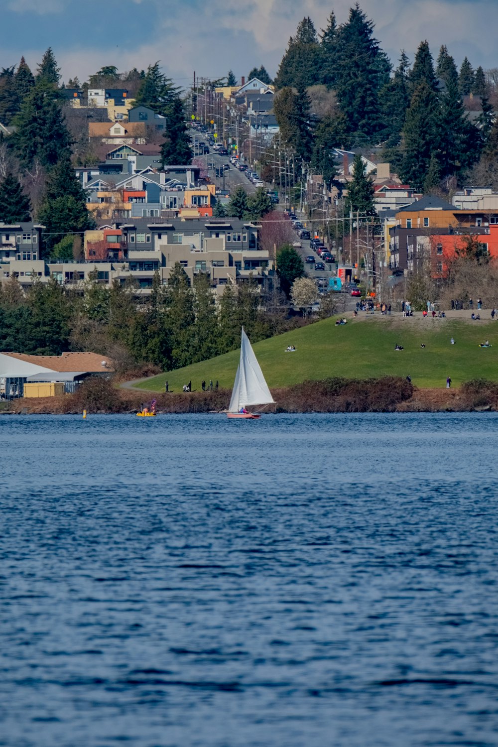a sailboat on a body of water with a city in the background