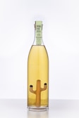 A bottle with light amber liquid, featuring a unique cactus shape inside. The label reads 'Porfidio 10+ Suave'.