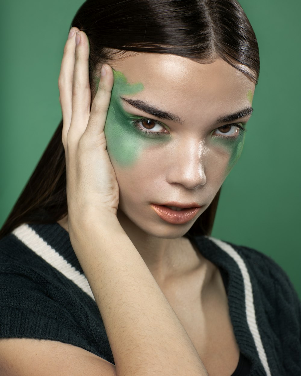 a woman with a green face paint on her face