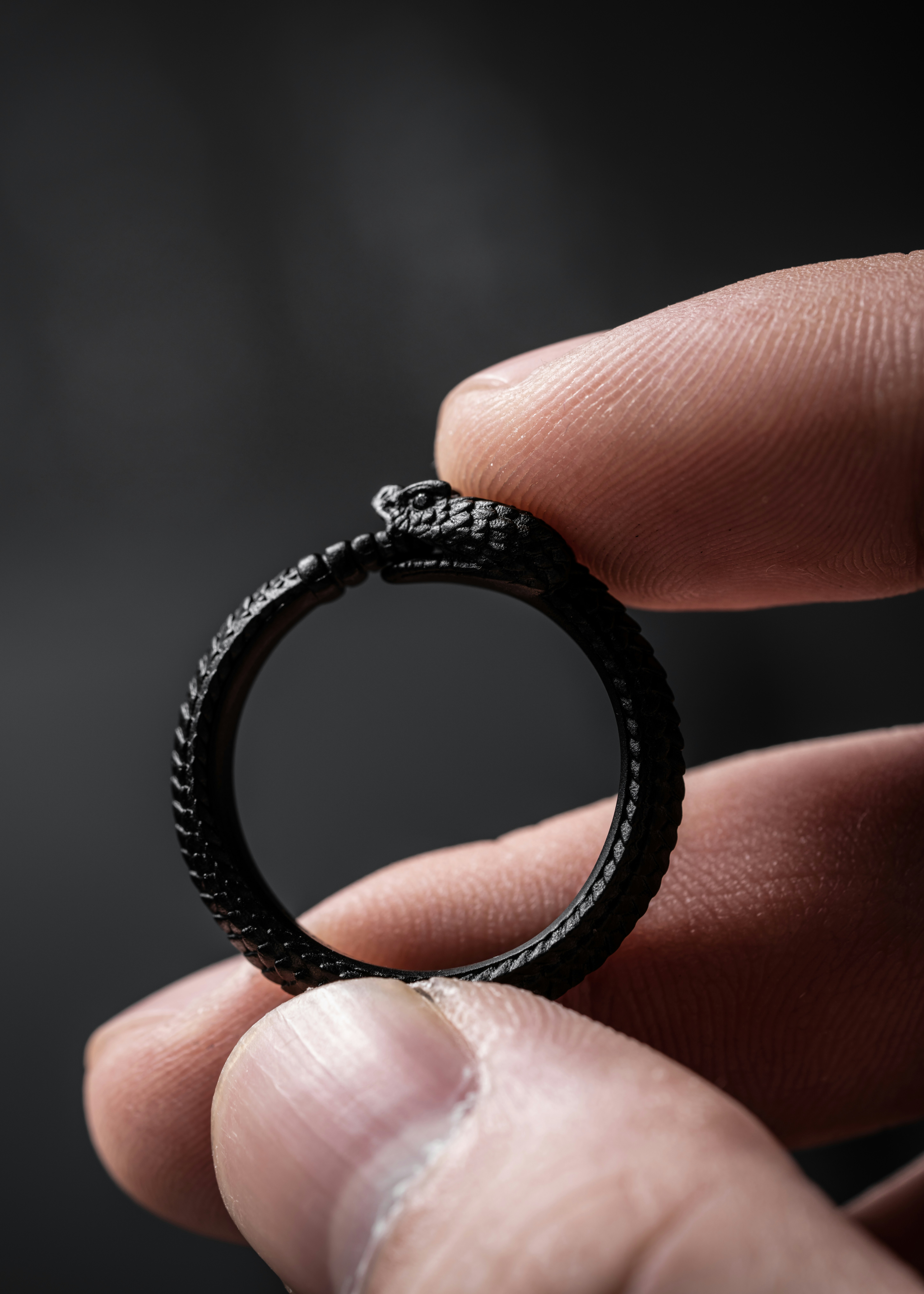 a person holding a black ring in their hand