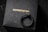 A black ring with a detailed snake design rests on a dark textured surface, with the brand name COPPERTIST.WU displayed in gold lettering.