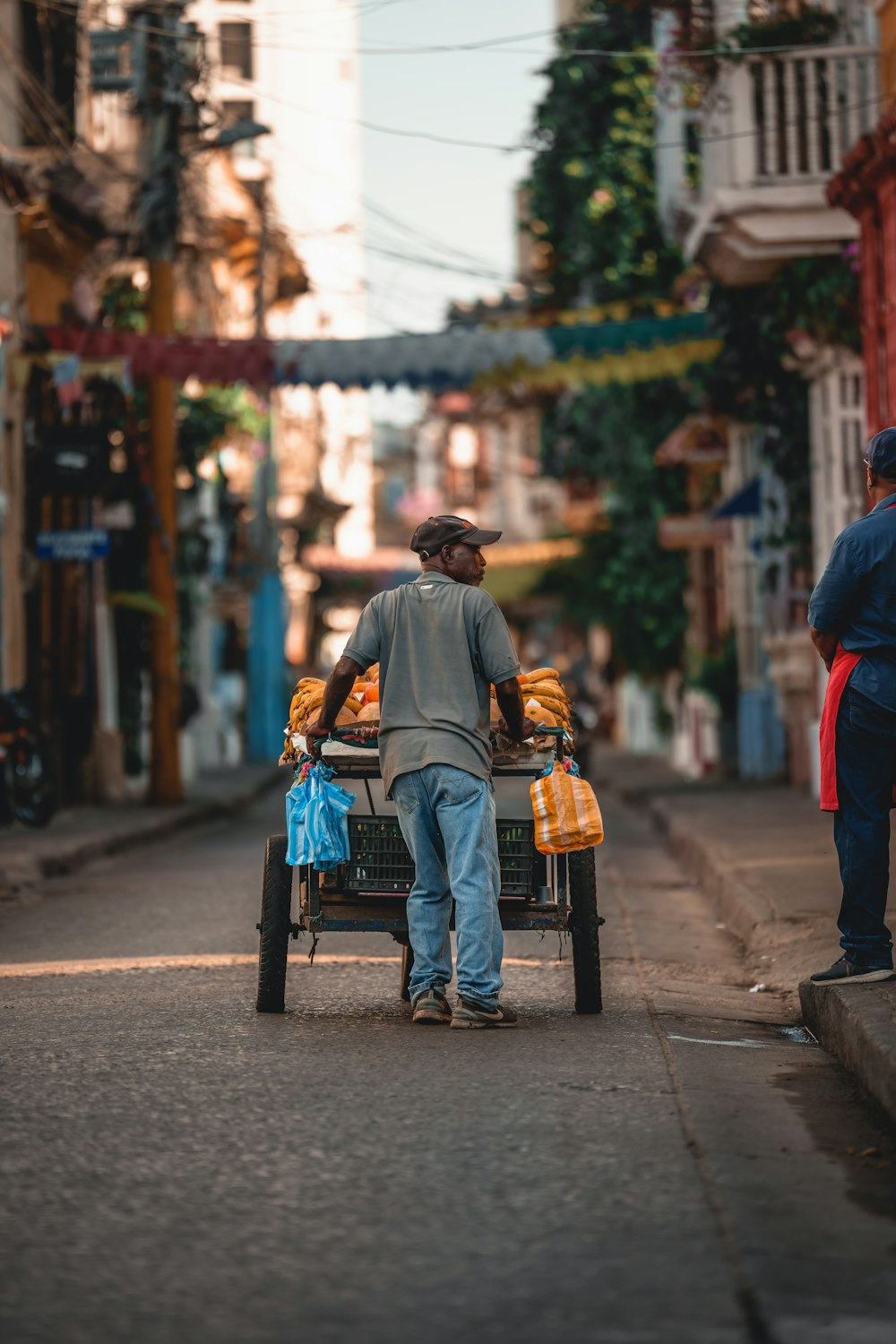 a man pushing a cart down a street