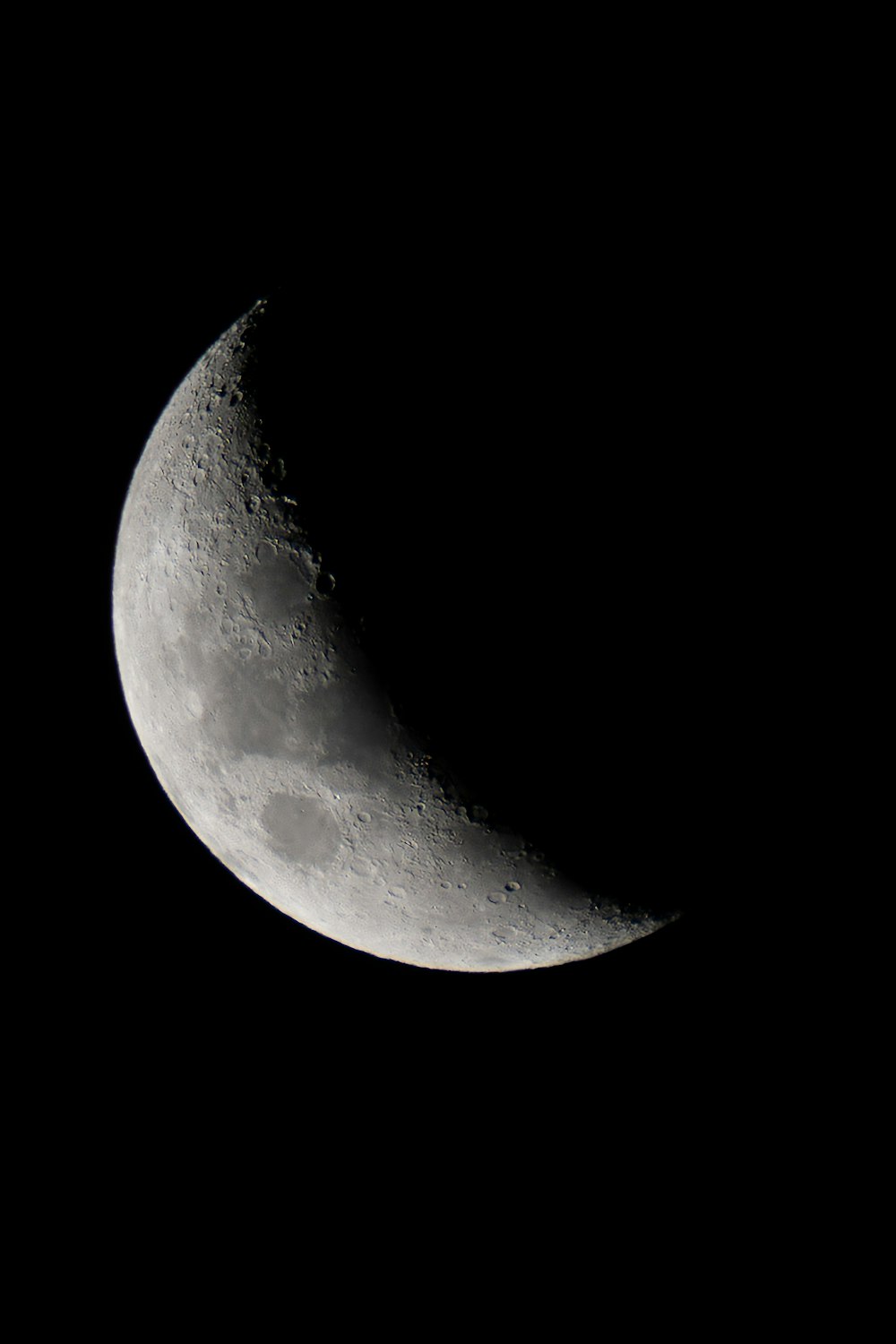 a half moon is seen in the dark sky