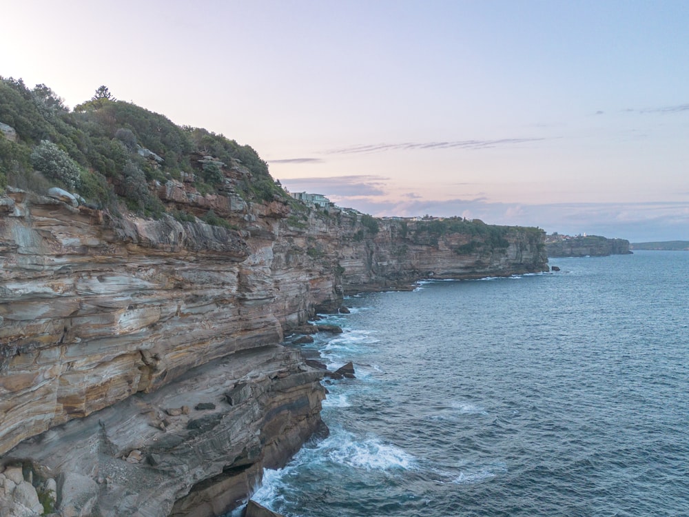 a rocky cliff overlooks a body of water