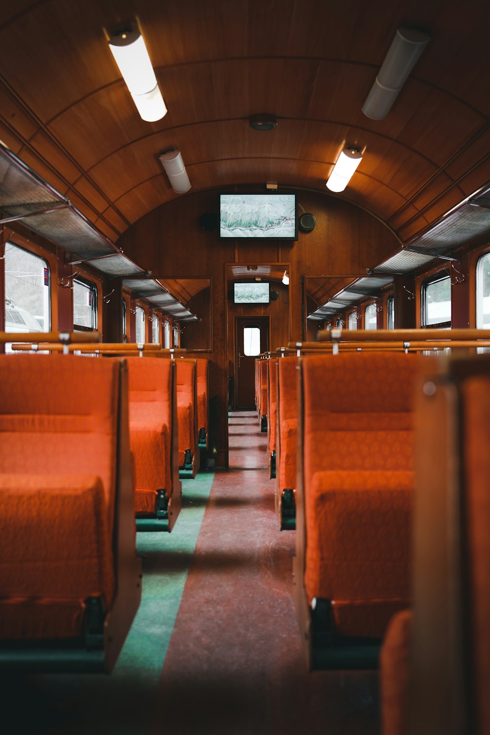 the inside of a train car with orange seats
