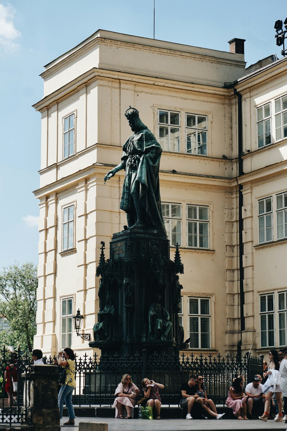 a group of people sitting around a statue in front of a building