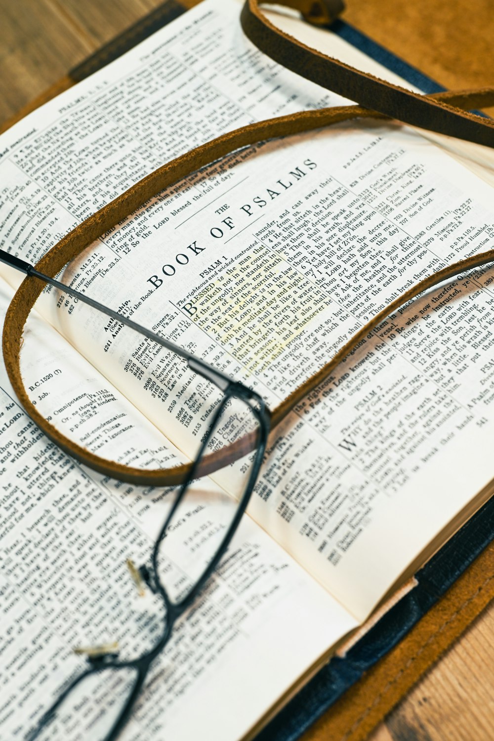 an open book with glasses on top of it