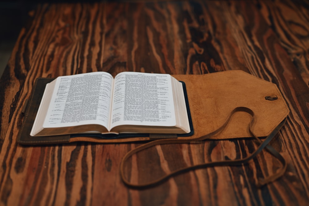 an open book sitting on top of a wooden table