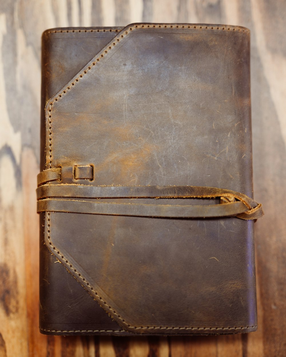 a brown leather journal sitting on top of a wooden table
