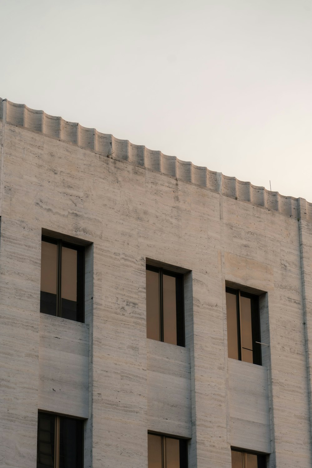 a building with three windows and a clock on the side of it