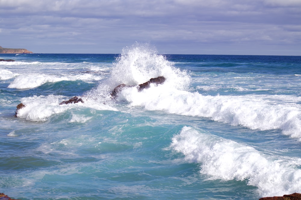 a wave crashes into the shore of the ocean