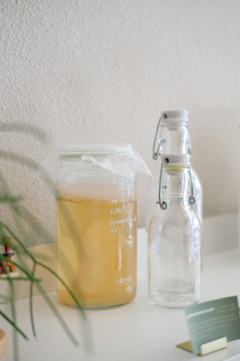 a jar of liquid next to a glass bottle of liquid