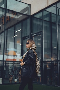 A stylish traveler wearing a pashmina and sunglasses, looking confidently into the distance.