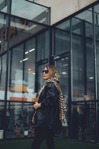 A fashion-forward model wearing Oscar Vision sunglasses on a sunny city street, showcasing trendy design and comfort.