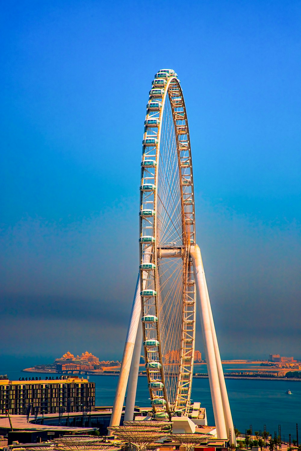 a large ferris wheel sitting next to a body of water