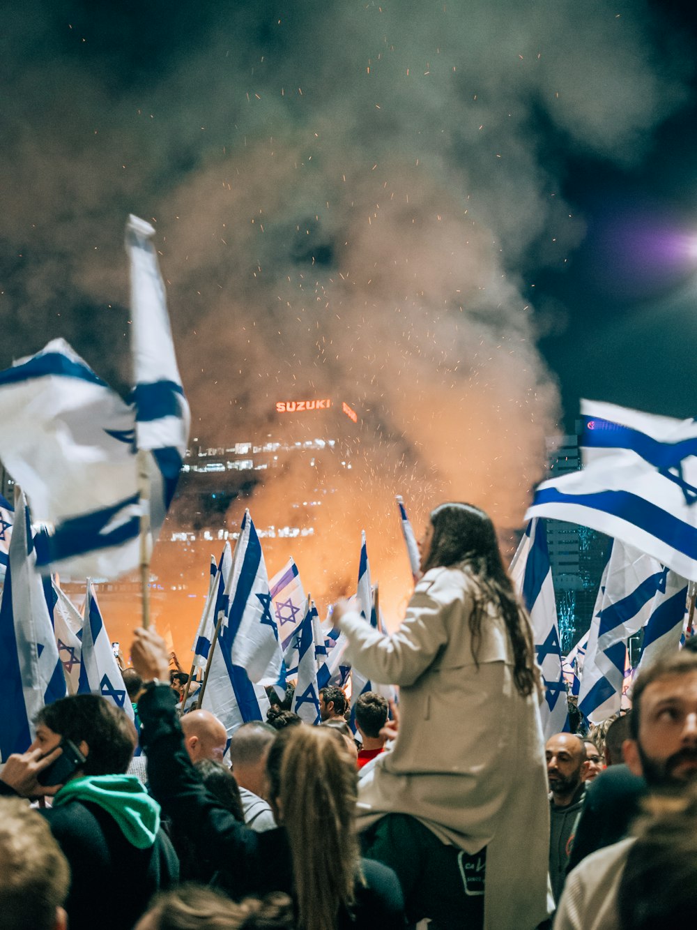 a large group of people holding flags in front of a crowd